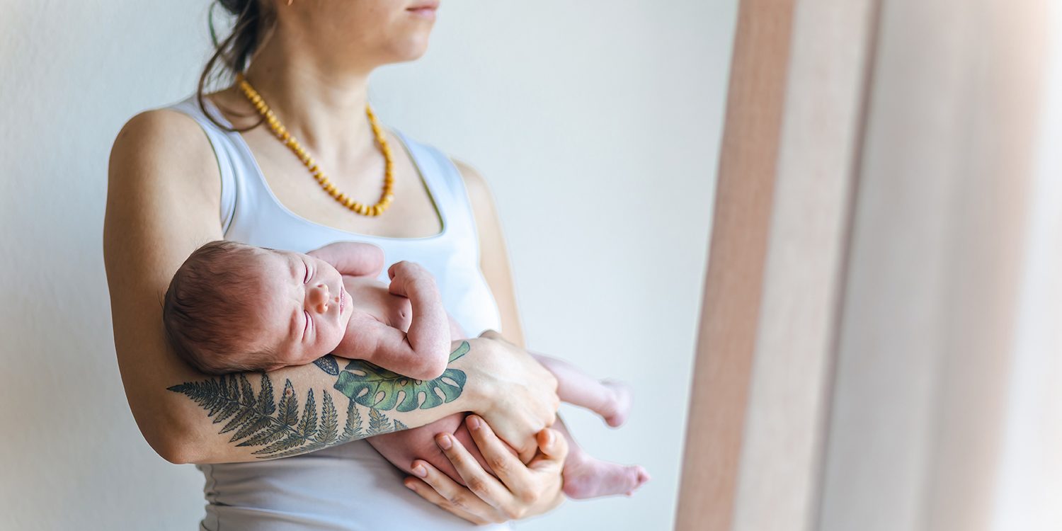 newborn-baby-in-the-arms-of-a-tired-mother-looking-2025-01-07-16-02-55-utc
